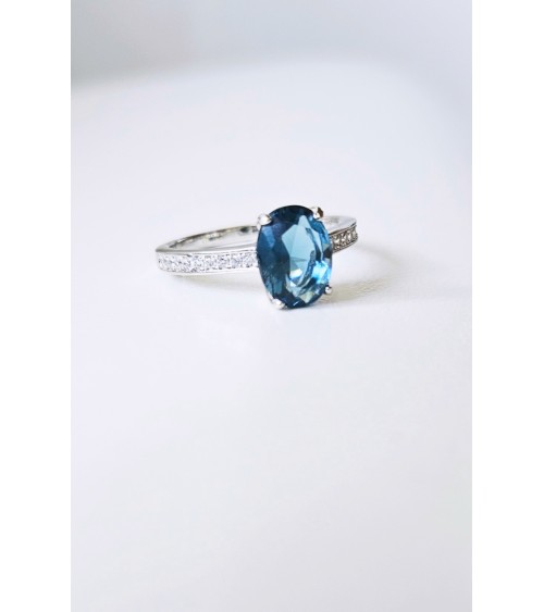 Bague solitaire de forme ovale couleur bleue saphir, en argent 925/1000 rhodié et oxydes de zirconium blancs