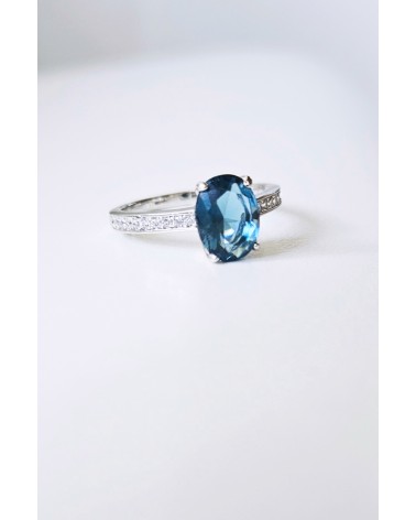 Bague solitaire de forme ovale couleur bleue saphir, en argent 925/1000 rhodié et oxydes de zirconium blancs
