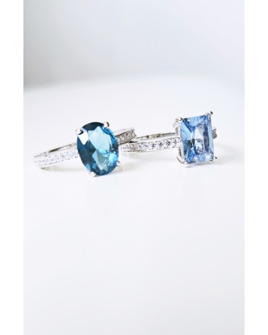 Bague solitaire de forme ovale couleur bleue saphir, en argent 925/1000 rhodié et oxydes de zirconium blancs