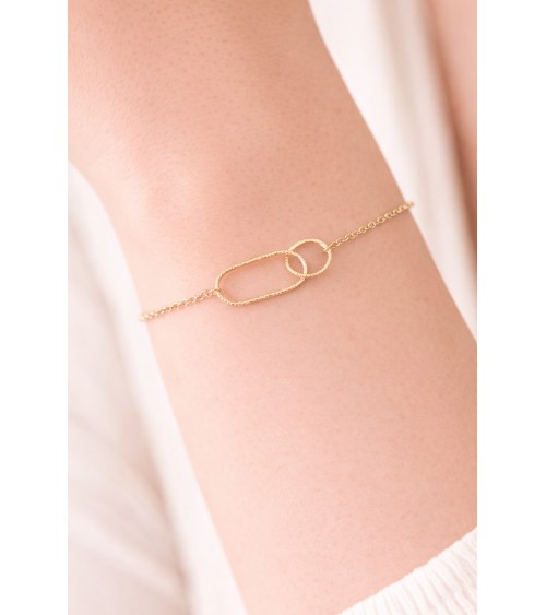 Bracelet en plaqué or avec un anneau rectangle et un anneau rond striés, entremêlés