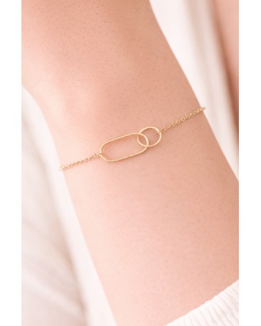 Bracelet en plaqué or avec un anneau rectangle et un anneau rond striés, entremêlés