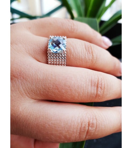 Bague anneau à picots en argent 925/1000 rhodié,surmontée d'un oxyde de zirconium de couleur "bleu clair"