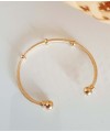 Bracelet rigide ouvert en plaqué or, comportant 3 intercalaires et 2 boules à chaque extrémité (diamètre 56 cm)
